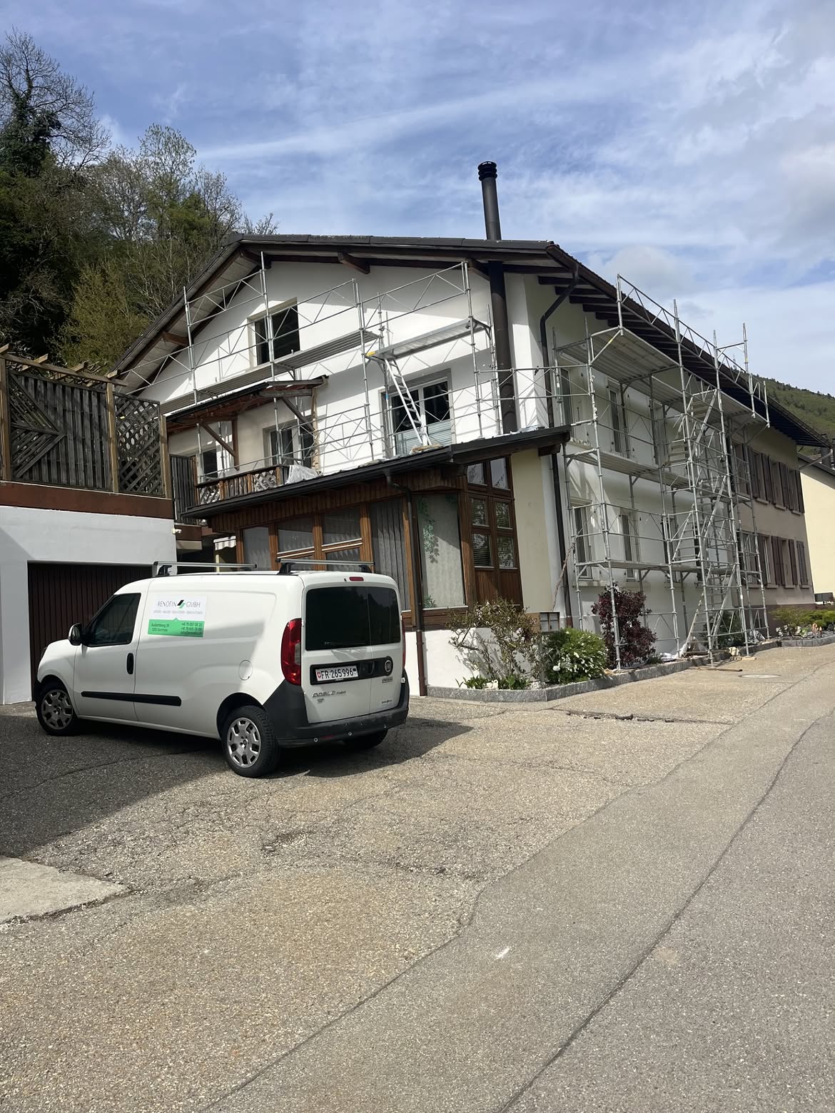 RENOFIN-Firmenwagen vor einer Fassadenrenovation mit Gerüst
