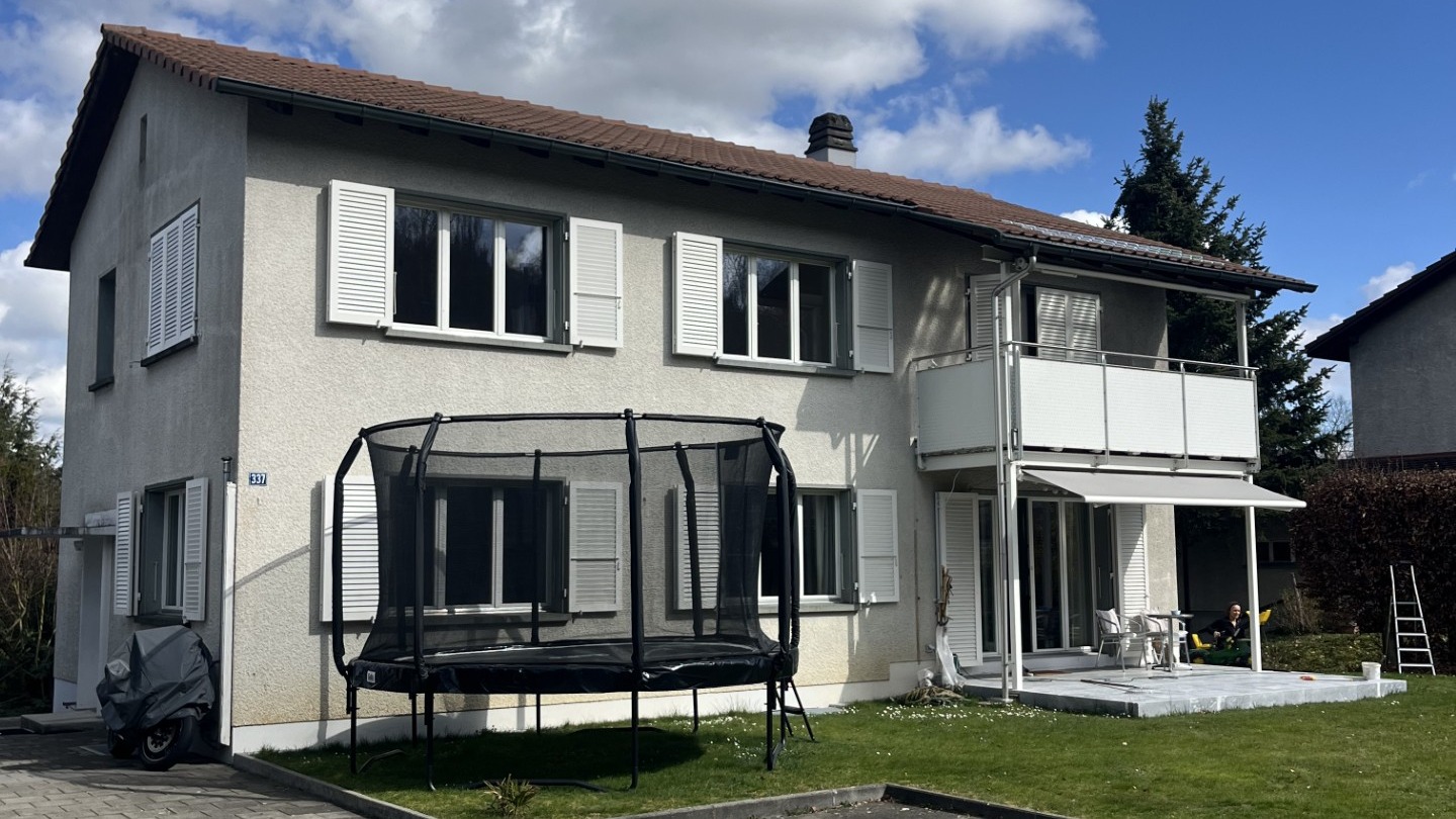 Wohnhaus mit grauer Fassade vor der Renovation